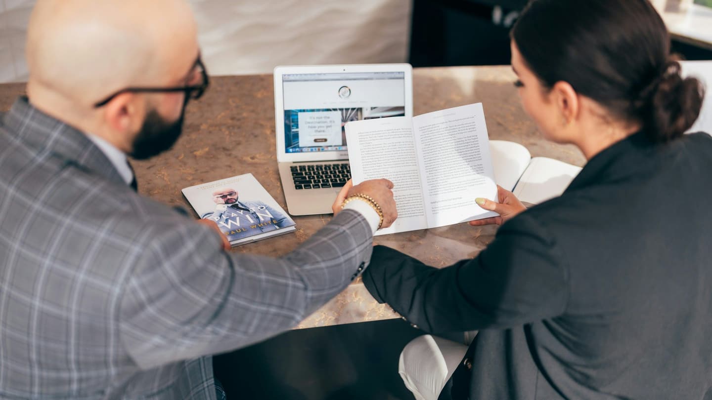Two people reviewing project documents together at a table
