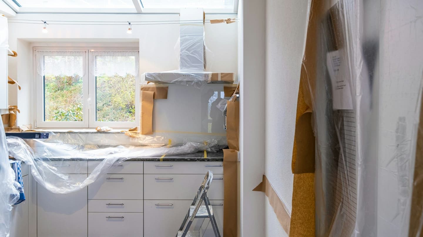 A kitchen part-way through a remodel, cabinets in and surfaces protected